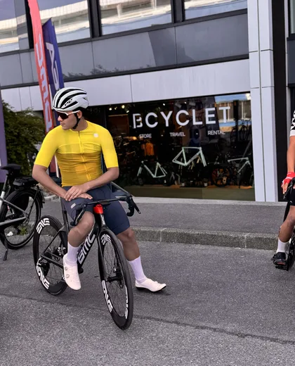 Cycliste en maillot jaune sur son vélo de location à Annecy